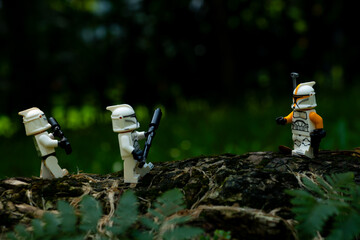 Obraz premium Depok, Indonesia - May 13, 2024: Lego toys photography, phase 1 clone troopers on a battle in jungle scene recreation, natural outdoor background
