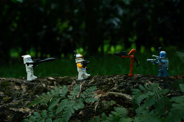 Obraz premium Depok, Indonesia - May 13, 2024: Lego toys photography, phase 1 clone troopers on a battle in jungle scene recreation, natural outdoor background