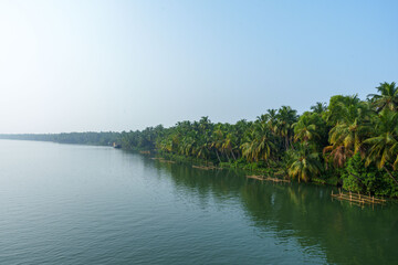 Fototapeta premium The scenic backwater near the Bekal Fort transports us to a serene environment away from the hustle and bustle. The mesmerizing view from a kettuvallam (houseboat) is probably the one thing that you n