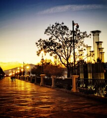 Un'affascinante immagine notturna di un lungomare illuminato da lampioni a sfera. La fila di...