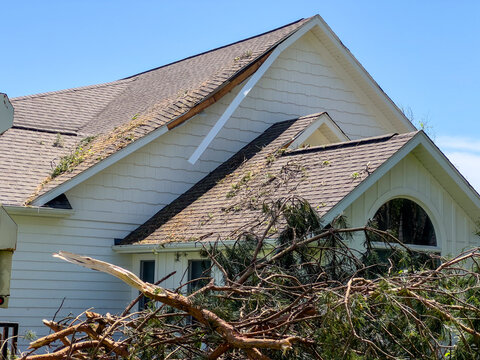Roof Damage to a home with fallen trees from Tornado in Michigan