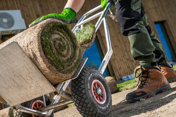 Landscaper pushing a cart filled with grass turfs