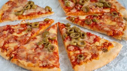 Olive Cheese Pizza on textured paper.