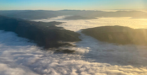 A fog bank between the mountains, at sunset, seen from above