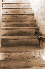 Old wooden stairs ascending upwards with a sepia effect