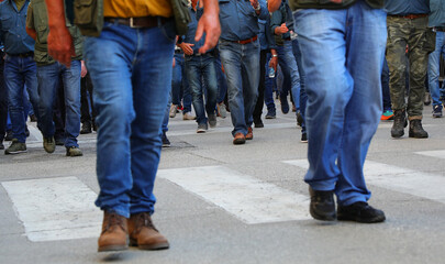 crowd of men walking down the street in jeans and their faces cannot be seen
