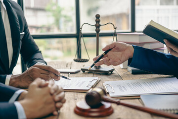 Lawyer working with client discussing contract documents with legal brass in consulting office to...