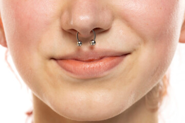 Obraz premium Closeup of a young smiling woman's visage with piercing septum hanging from her nose