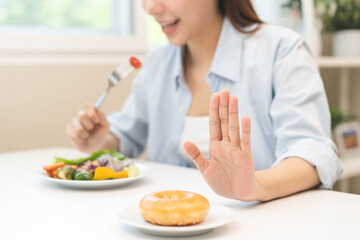 Diet concept, close up young woman, girl using hand push out, stop sweet donut, dessert or junk...