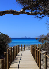 Footbridge on a sandy beach in Formentera with a wiew on Es Vedrà – Ibiza