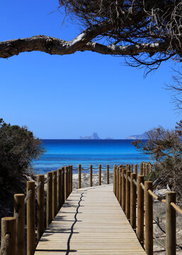 Footbridge on a sandy beach in Formentera with a wiew on Es Vedr&agrave; &ndash; Ibiza