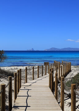 Footbridge on a sandy beach in Formentera with a wiew on Es Vedr&agrave; &ndash; Ibiza