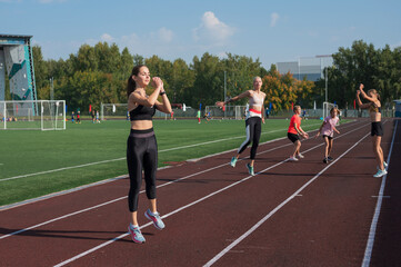 Obraz premium Group of young athletes training at the stadium. School gym trainings or athletics