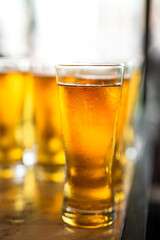 Amber lager beer in glasswares which are prepared for the party event. Refreshment drinking, close-up and selective focus. 