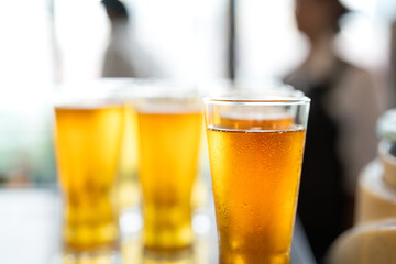 Amber lager beer in glasswares which are prepared for the party event. Refreshment drinking, close-up and selective focus. 
