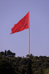 Turkish flag, on a red background white star and moon. Turkish flag flies in the wind against the backdrop of Istanbul