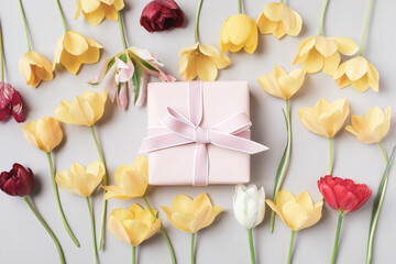 Beautiful aesthetic composition with gift box and flowers on neutral beige background. Greeting card in modern style.