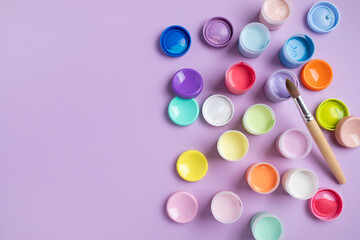 Pastel colors gouache in jars on table top view. Creative hobby painting concept.