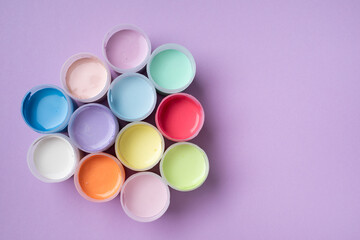 Pastel colors gouache in jars on table top view. Creative hobby painting concept.