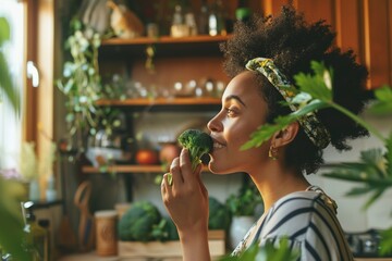 Smiling young woman smelling broccoli in kitchen