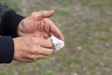 Man wiping his hands with an antibacterial wet wipe.Hands close-up.