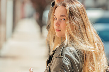 blonde girl on the street outdoors with mobile phone