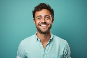 Obraz premium Portrait of a grinning man in his 30s smiling at the camera isolated in pastel teal background