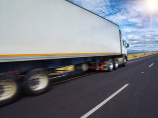 motion blur of truck speeding on the highway at sunset, haulage and logistics concept