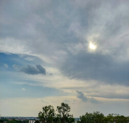 Beautiful blue sky background,  sun hiding behind clouds over the field, nature photography