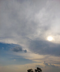 Beautiful blue sky background,  sun hiding behind clouds over the field, nature photography