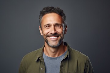 Obraz premium Portrait of a content man in his 40s smiling at the camera isolated in pastel gray background