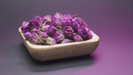 Dried rose buds in wooden bowl