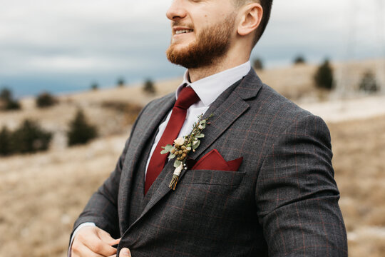 Close-up photo of a man in suite wearing red tie