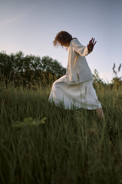 woman in white dress walking in nature