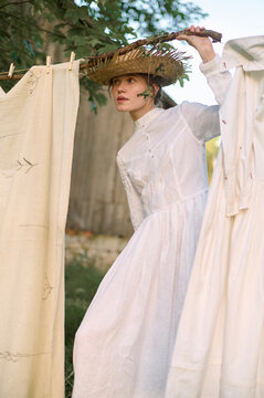 village woman hangs clothes in nature