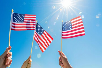 Hands hold American flags against a background of blue sky and bright sun. American Patriotism concept, 4th July independent Day.
