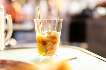 Soft-boiled eggs in glass with seasoning sauce and ground pepper; Thai breakfast vintage style.