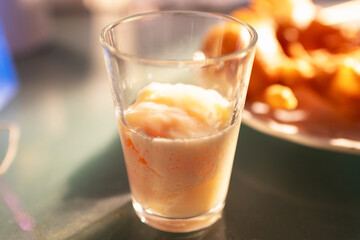 Soft-boiled eggs in glass with seasoning sauce and ground pepper; Thai breakfast vintage style.
