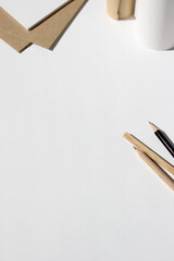 Design Studio Flatlay. Kraft Paper Rolls, Sheets of Paper, Graphite Pencils Arranged on Desk. Sketching Mockup.