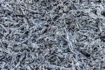 A close-up view of a pile of ashes, remnants of a fire, with intricate textures and tones, representing transformation and renewal.