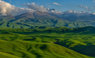 Fototapeta premium A picturesque plateau against the backdrop of snow-covered peaks in the Trans-Ili Alatau (Kazakhstan)