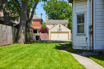 Obraz premium Suburban Backyard with Basketball Hoop and Detached Garage, Eye-Level View