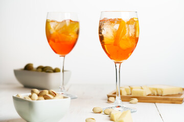 Happy hour with Aperol Spritz served with an orange slice in wine glasses