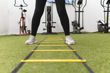 A woman is standing in front of a yellow ladder