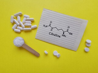 Citrulline is an amino acid, used as a supplement for health and exercise performance. Structural chemical formula of citrulline molecule with spoonful of citrulline powder and white tablets.
