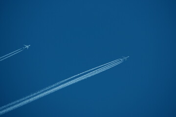 two parallel airplane tracks in the blue sky, contrails