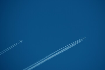 two parallel airplane tracks in the blue sky, contrails