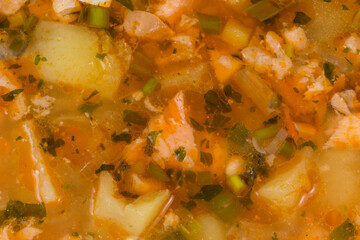 Background of clear salmon soup in bowl, fragment close-up