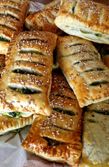 Ruddy puff pastry with spinach and sesame. Bakery. Vertical photo.