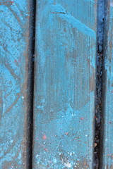 Old blue peeling paint on a wooden board.